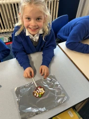 A girl smiling with her chocolate lollipop