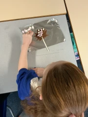 A girl making a chocolate lollipop