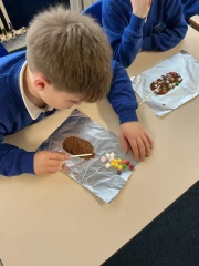 A boy and a girl making seperate chocolate lollipops