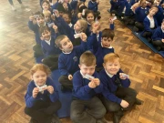 Year One children showing their bus tickets for a tour of London