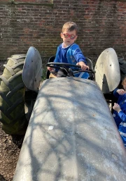 A boy on a tractor at the farm
