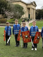 Four boys holding Roman swords and shields. (1)