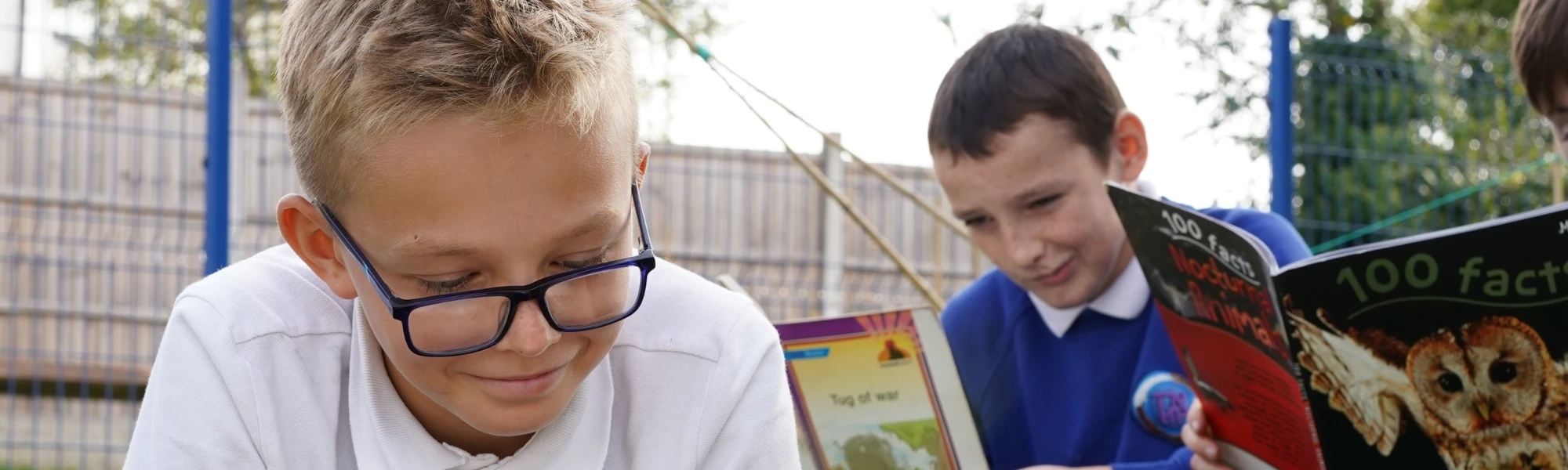 Children reading outdoors